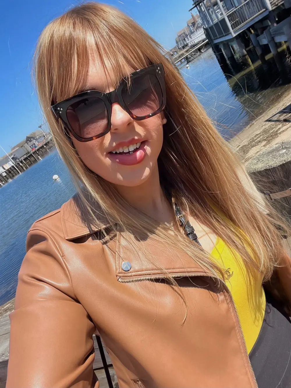 Emma Shorebreak on the Nantucket waterfront during Daffodil Weekend in late April, wharf cottages and the harbor behind her