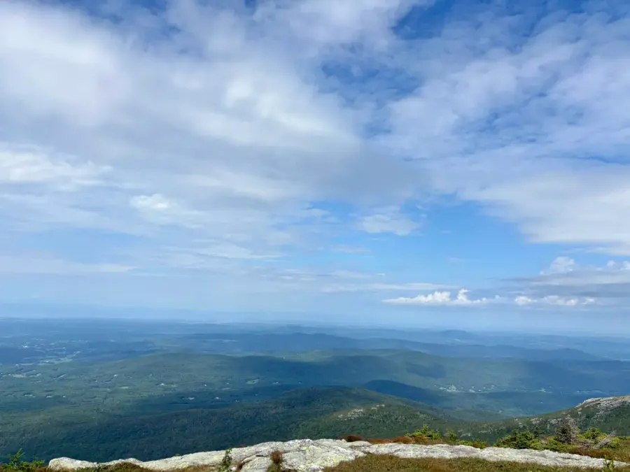 The view south along the spine of the Green Mountains from the ridge on Mount Mansfield, grey rock and alpine scrub in front, hazy ridgelines to the horizon